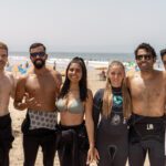 Solo female surfer walking on beach Tamraght Morocco sunset